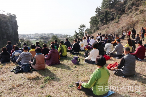 제주를 찾은 명상여행단이 제주 서귀포 대평리 선비돌기 바위가 보이는 삼합비경에서 명상을 하고 있다.