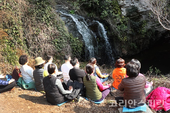 제주 서귀포 대평리 폭포 앞에서 명상여행단이  명상을 하고 있다.