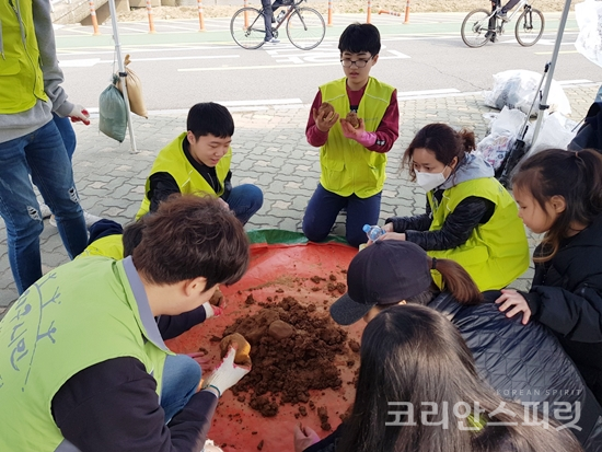 지난 26일 서울 양천구 안양천 일대에서 열린 물의 날 행사에서 시민들이 EM흙공 만들기 체험을 하고 있다. [사진=지구시민운동연합 서울강남2지부]
