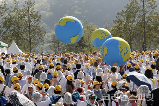 천안 한민족역사공원에서 4월 21일 열린 지구시민대회에서 참가자들이 지구본 3개를 전달하는 퍼포먼스를 하고 있다. [사진= 김경아 기자]