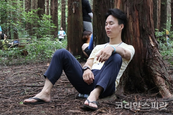 한국 이코 회원이 편백나무에 몸을 기대어 휴식을 취하고 있다. [사진=김민석 기자]