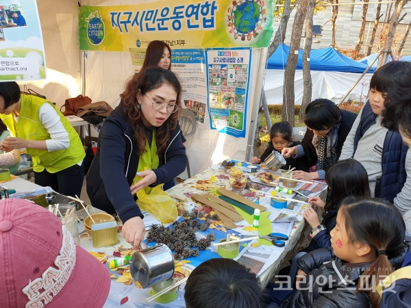 지구시민운동연합 강남1지부가 '2018 잠실 석촌호수 단풍&낙엽축제'에 참가하여 재활용 쓰레기를 이용한 '낙엽 양초 만들기' 체험 부스를 운영하고 있다. [사진=지구시민운동연합 강남1지부]