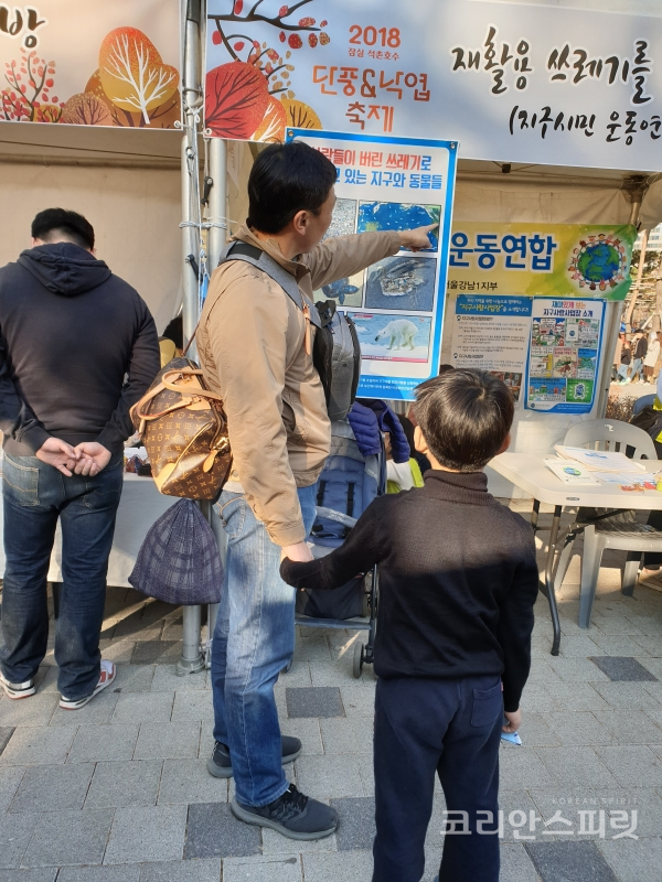 부모님들은 자녀에게 '우리가 버린 쓰레기로 고통 받고 있는 동물들' 현수막에 걸린 사진을 보며 직접 설명해주기도 했다. [사진=지구시민운동연합 서울강남1지부]