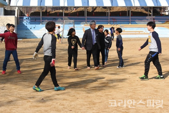 이재명 교장이 중간놀이시간에 아이들과 운동장에서 맨발걷기를 하고 있다. [사진=호서남초등학교]