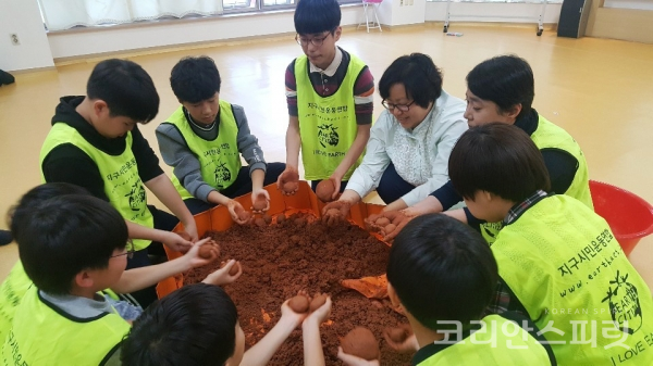 황토와 EM발효액을 이용해 흙공을 만드는 '봉선마을 방범대' 학생들 [사진=지구시민운동연합 광주전남지부]