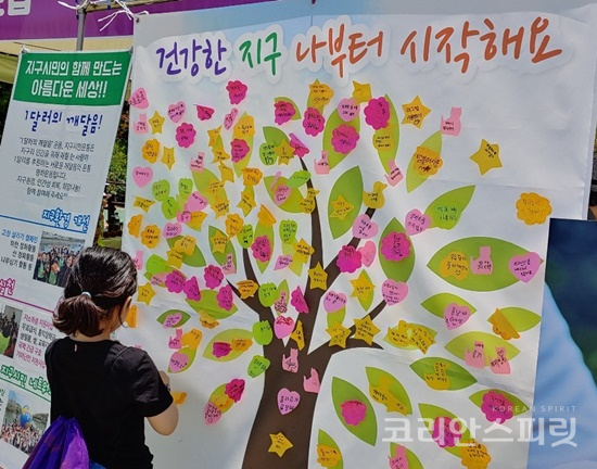 지구시민운동연합 충북지부가 개최한 지구시민BHP명상 캠페인에서 한 어린이가 지구 사랑메시지를 적어 희망나무에 붙이고 있다. [사진=지구시민운동연합 충북지부]