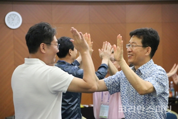 충북도립대학교 교직원 역량 강화 워크숍에 참가한 이들이 짝을 지어 체조를 하고 있다. [사진=벤자민인성영재학교]