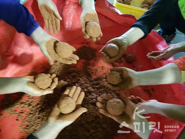 친환경 미생물 EM발효액으로 하천을 정화할 흙공을 만드는 참가자들. [사진=지구시민운동연합 충북지부]