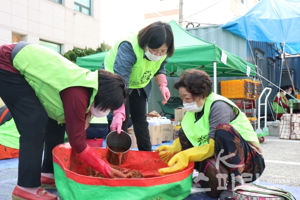 자원봉사자들이 EM용액과 발효액을 섞어 반죽을 만들고 있다. [사진=김경아 기자]