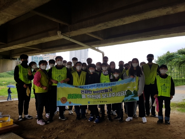 Em 흙 공을 만든후 한국영재학원에서 온 봉사자들과 함께사진=지구시민연합 충북지부