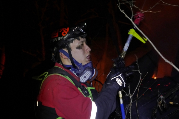 산림청 산림항공본부 소속 공중진화대원이 7일 경북 울진군 북면 안말래길에서 금강소나무숲을 지키기 위해 밤샘 산불 진화 작업을 벌이다 지친 숨을 고르고 있다. [사진=산림청 제공]