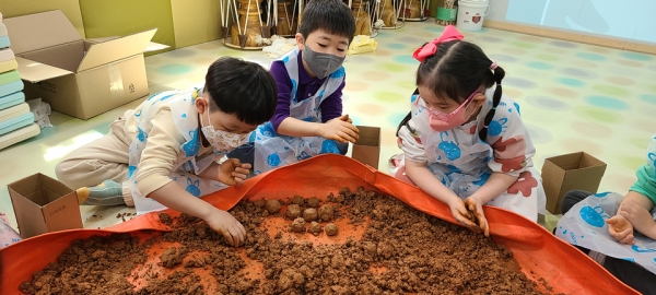 지난 21일 충남 천안 성성호수어린이집 아이들이 부모와 함께 지구시민 교육 후 하천을 살리는 EM흙공을 직접 만들었다. [사진=지구시민연합 충남지부]