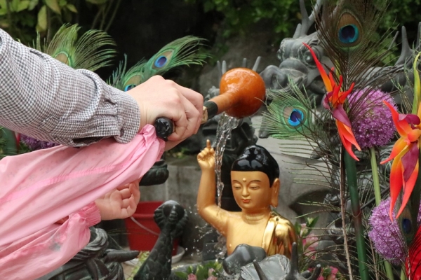 부처님 오신 날을 맞은 봉원사에서 갓 태어난 석가모니 부처를 씻어주는 의식을 하는 아빠와 딸. [사진=강나리 기자]