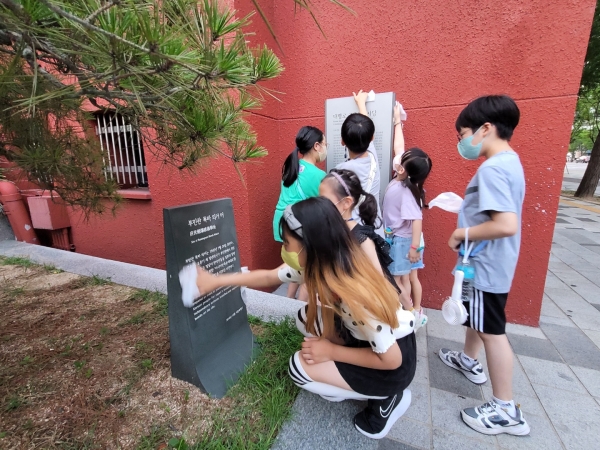 부민관 폭파 의거터 표지판을 닦고 있는 어린이들. [사진 (사)우리역사바로알기]
