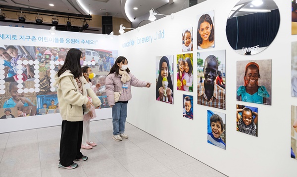 ‘2023년 유니세프 달력그림 그리기’ 공모전 수상 어린이들이 사진을 관람하고 있다. [사진 유니세프한국위원회]