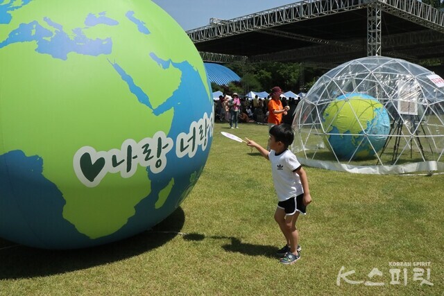 친환경 스티커로 직접 꾸민 부채로 지구에 부채질을 하는 아이. 사진 강나리 기자.