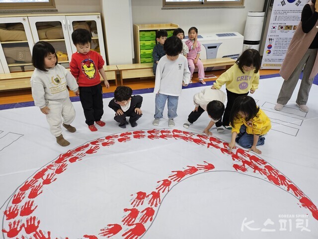 유치원 아이들의 작은 손도장 하나 하나로 완성되어가는 태극. 사진 김가령 기자.
