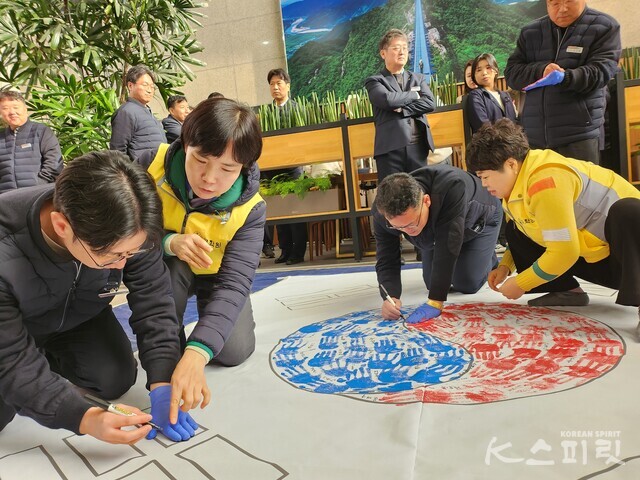 손도장을 꾹 눌러 도장을 찍고 이름을 쓰는 한국도로공사 대경본부 임직원들. 사진 박재연 기자
