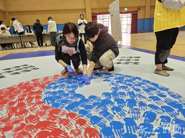 오창중학교 학생들이 태극기에 손도장과 자신의 이름을 남겼다. 사진 김가령 기자.
