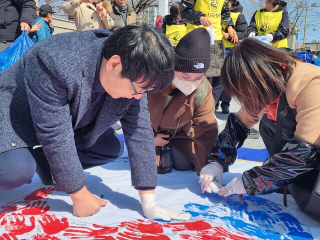 삼일절 기념식장을 찾은 시민들이 손도장과 서명으로 태극기를 완성해나가는 모습. 사진 부산국학원.