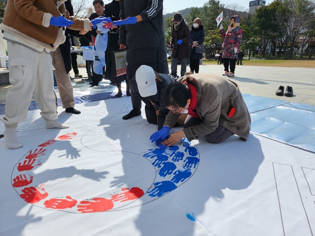 전남국학원이 개최한 3.1절 경축행사에서 참가자들이 손도장을 찍어 태극기를 만들고 있다. 이미지 전남국학원