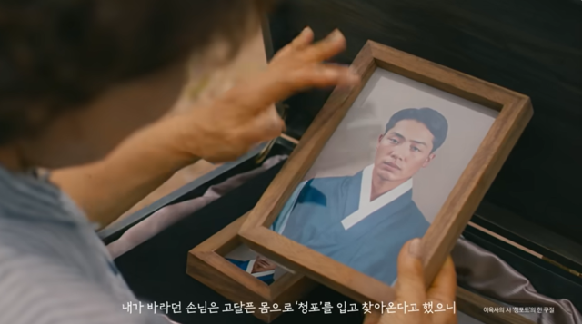 캠페인 영상 속 이원록 지사의 딸 이옥비 씨가 아버지의 묘소에 복원된 영정을 매만지는 모습. 사진 '처음 입는 캠페인' 영상 갈무리.