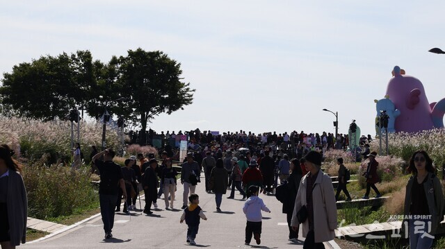 서울의 해치 캐릭터 주변에 갈대밭 버스킹을 기다리는 시민들. 사진 강나리 기자.