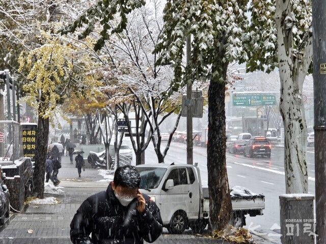 계속 내리는 눈을 뒤집어쓴 시민과 서울 강남 도로. 27일 오후 1시 20분 선정릉역 일대. 사진 강나리 기자.