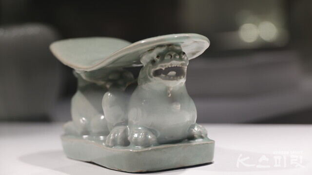 12세기 고려 청자 사자모양 베개. 두 마리의 사자가 등을 맞대고 웅크려 앉아 있는데 눈 높이를 낮추면 익살스러운 사자의 표정까지 확인할 수 있다. 사진 강나리 기자.