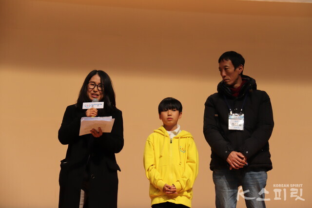 학부모 대표로 무대에 오른 송시율 학생(가운데) 어머니 여인숙 씨와 아버지 송상목 씨. 사진 윤수현 기자.