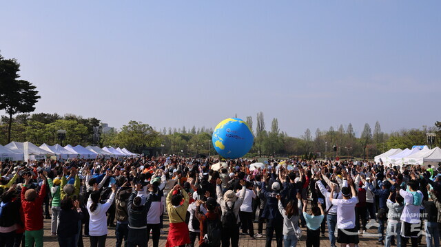 '지구와 인간의 공생'을 주제로 한 대회에 출전한 시민들이 상징물인 대형 지구공을 들어올려 띄우고 있다. 사진 강나리 기자.