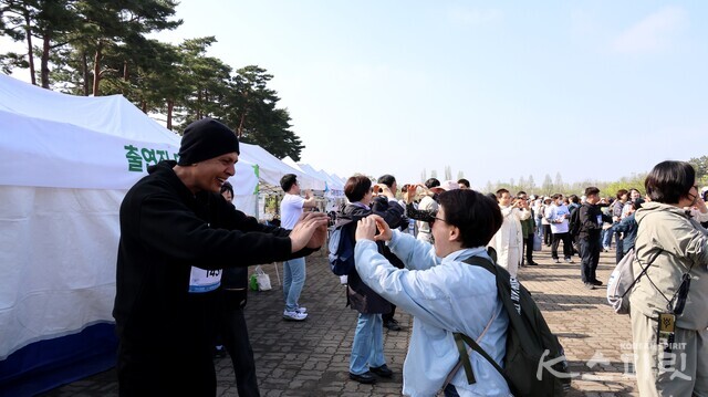 '2025 지구시민 런' 서울행사에 참가한 외국인 출전자와 동그란 지구를 상징하는 손모양으로 마음을 전하는 시민. 사진 강나리 기자.