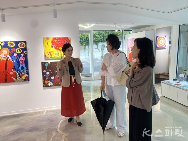 부암동 갤러리 B.O.S에서 ‘기억은 축복같은 행복’전展을 찾은 시민과 만난 이청자 작가. 사진 갤러리 B.O.S