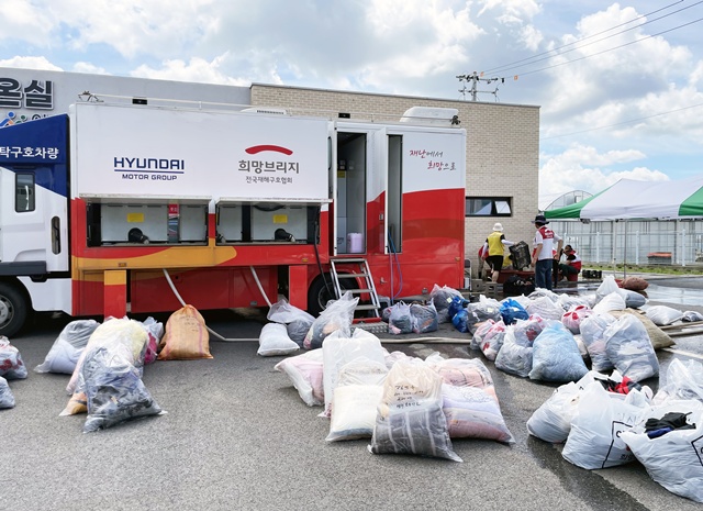 충남 아산 미래농업인센터 앞에 설치한 희망브리지 세탁구호차량. 수해 피해를 입은 이재민들의 의류와 이불 등을 수거해 현장에서 직접 세탁·건조하는 작업을 하고 있다. 사진 희망브리지