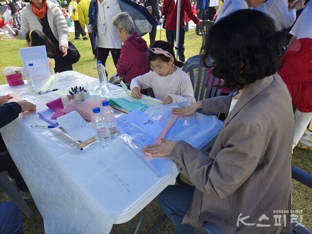 제7회 선도문화축제 한마당에서 소원지 쓰기 체험을 하는 엄마와 딸 참가자. 사진 강나리 기자.